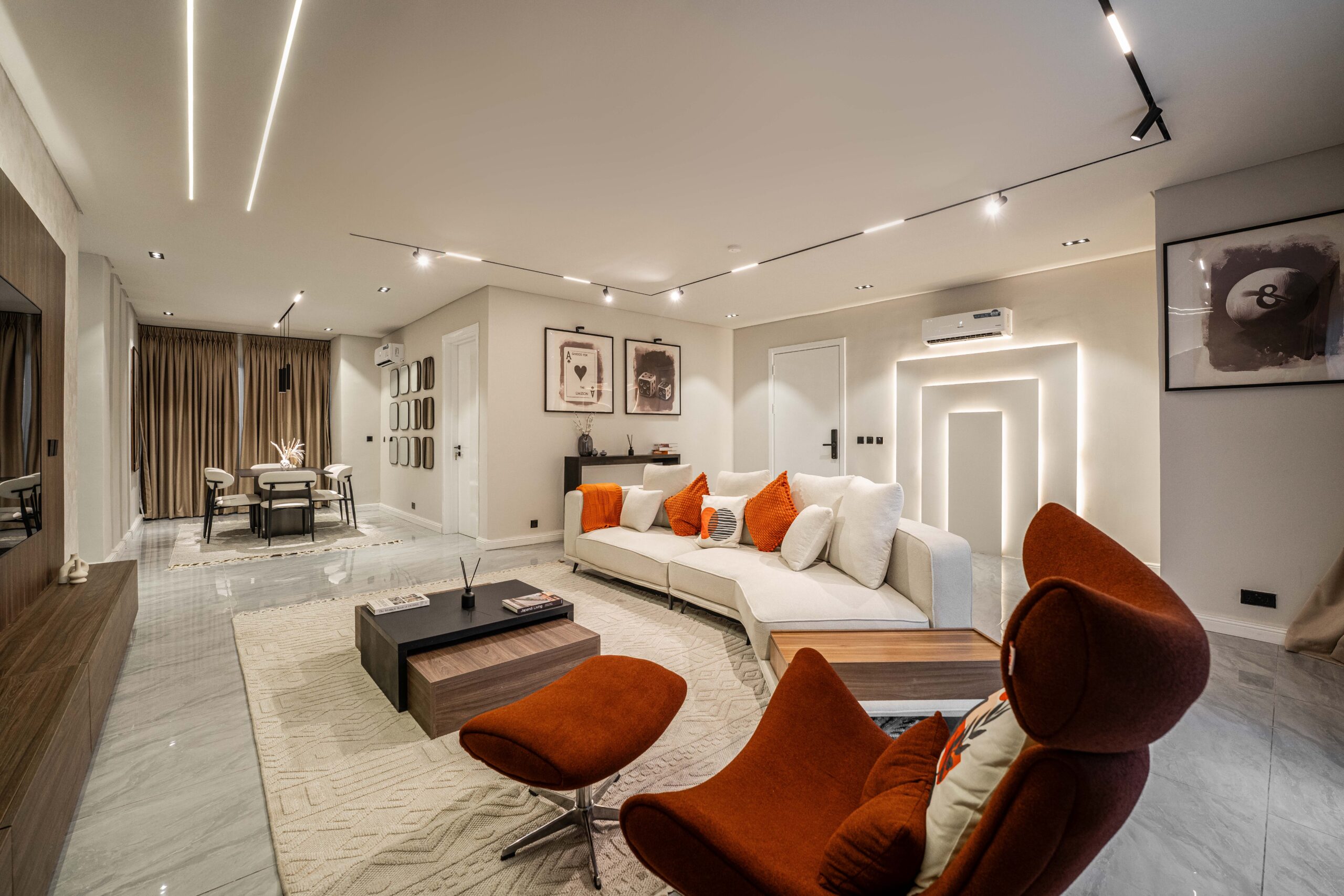 George Residence living room, walnut media wall, white sectional with amber cushions and marble floors